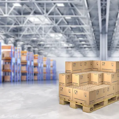 Cardboard boxes stacked on pallets in a warehouse.