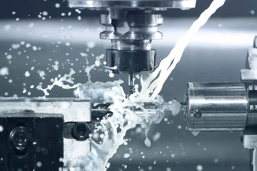 Black and white photo shows a drill with cooling spray water