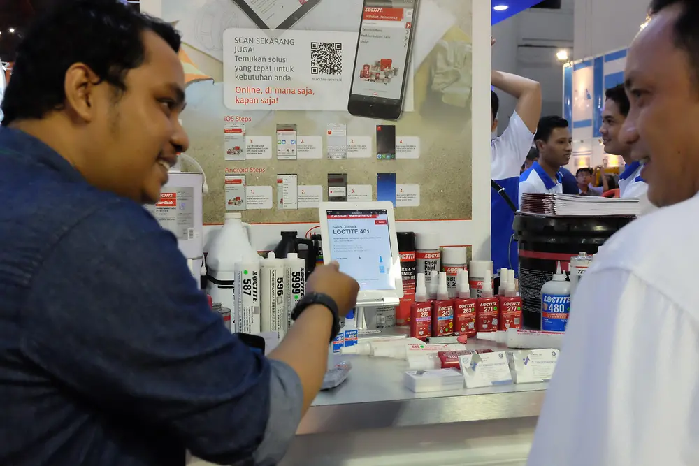 Henkel employees demonstrate the simplicity of using the Loctite Maintenance Expert Mobile Guide at Manufacturing Indonesia Expo.