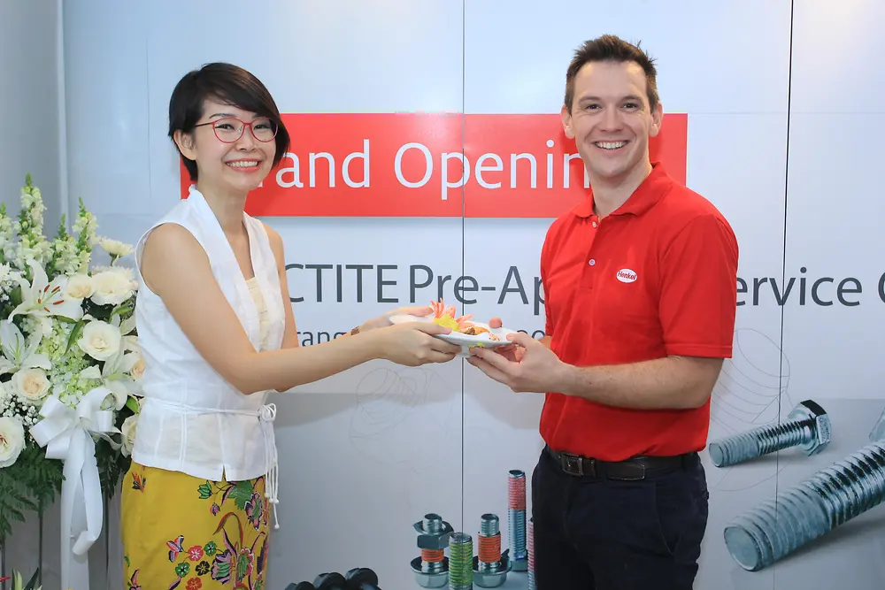 Amelia Simadibrata, Director of PT Stahl Arbeit (left), and Dale Jamieson, Southeast Asia Business Manager for Automotive Adhesives at Henkel (right), celebrate the grand opening of the Pre-Applied Application Center with a Tumpeng, a traditional Indonesian dish for auspicious occasions.